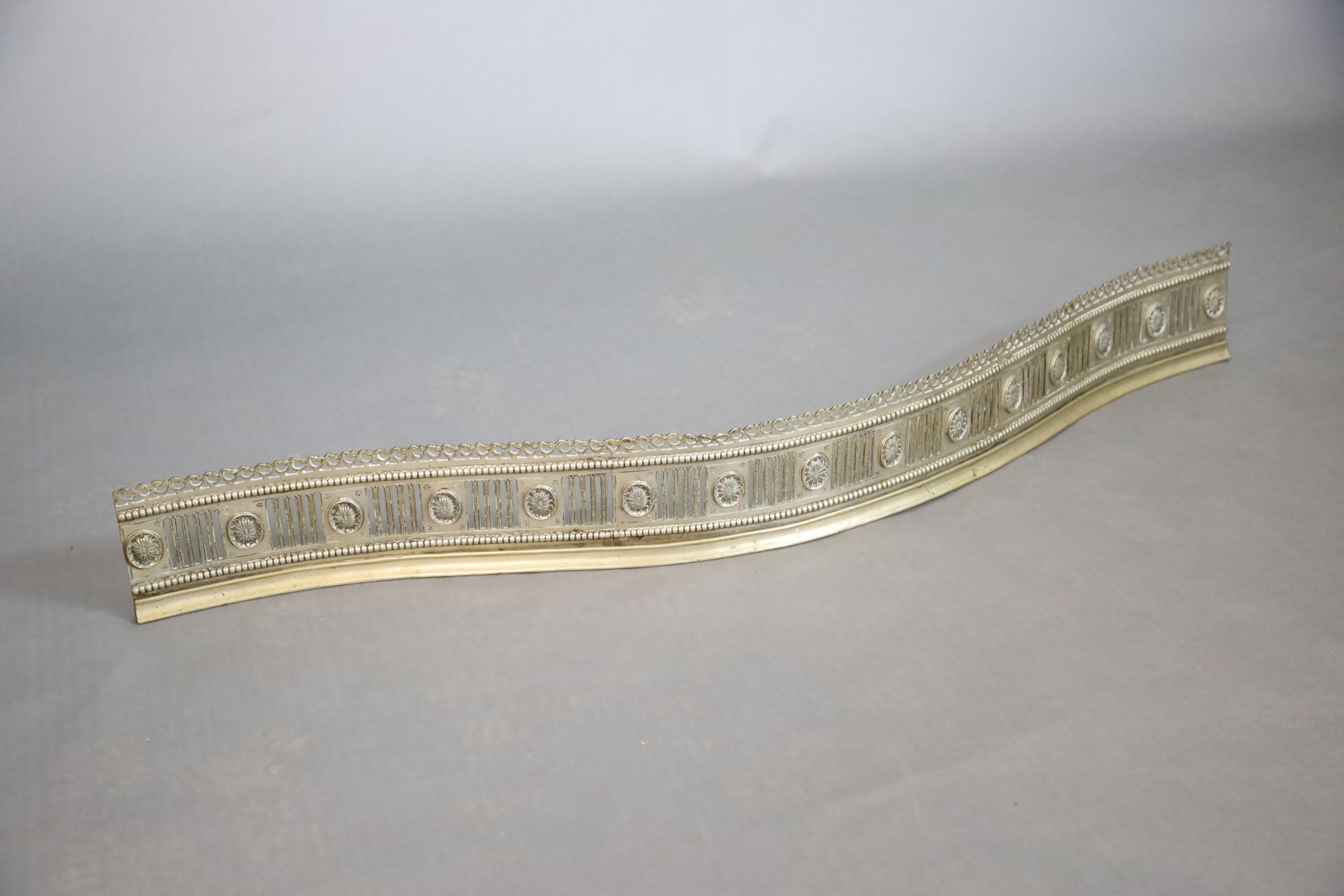 A George III bowed neo-classical fluted and pierced fender, W.145cm